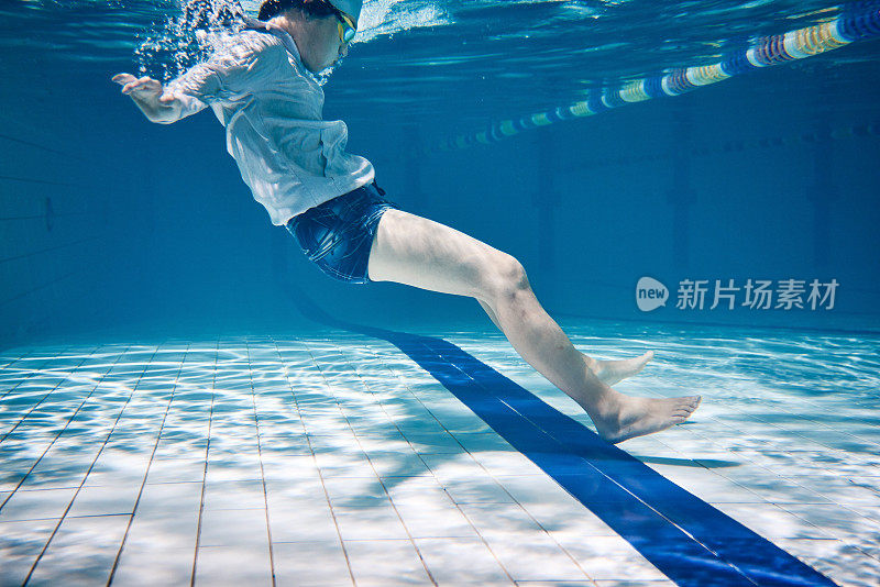 Male swimmer swimming underwater in a pool